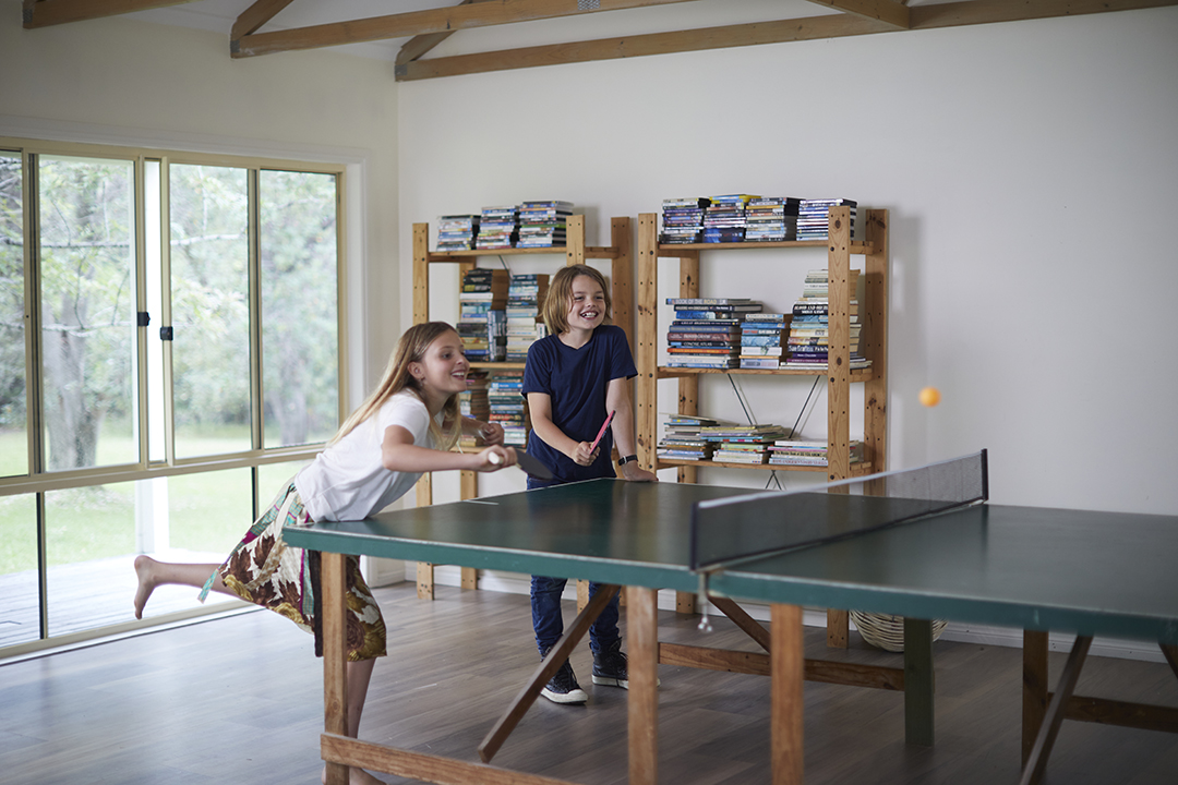 2 children play table tennis indoors